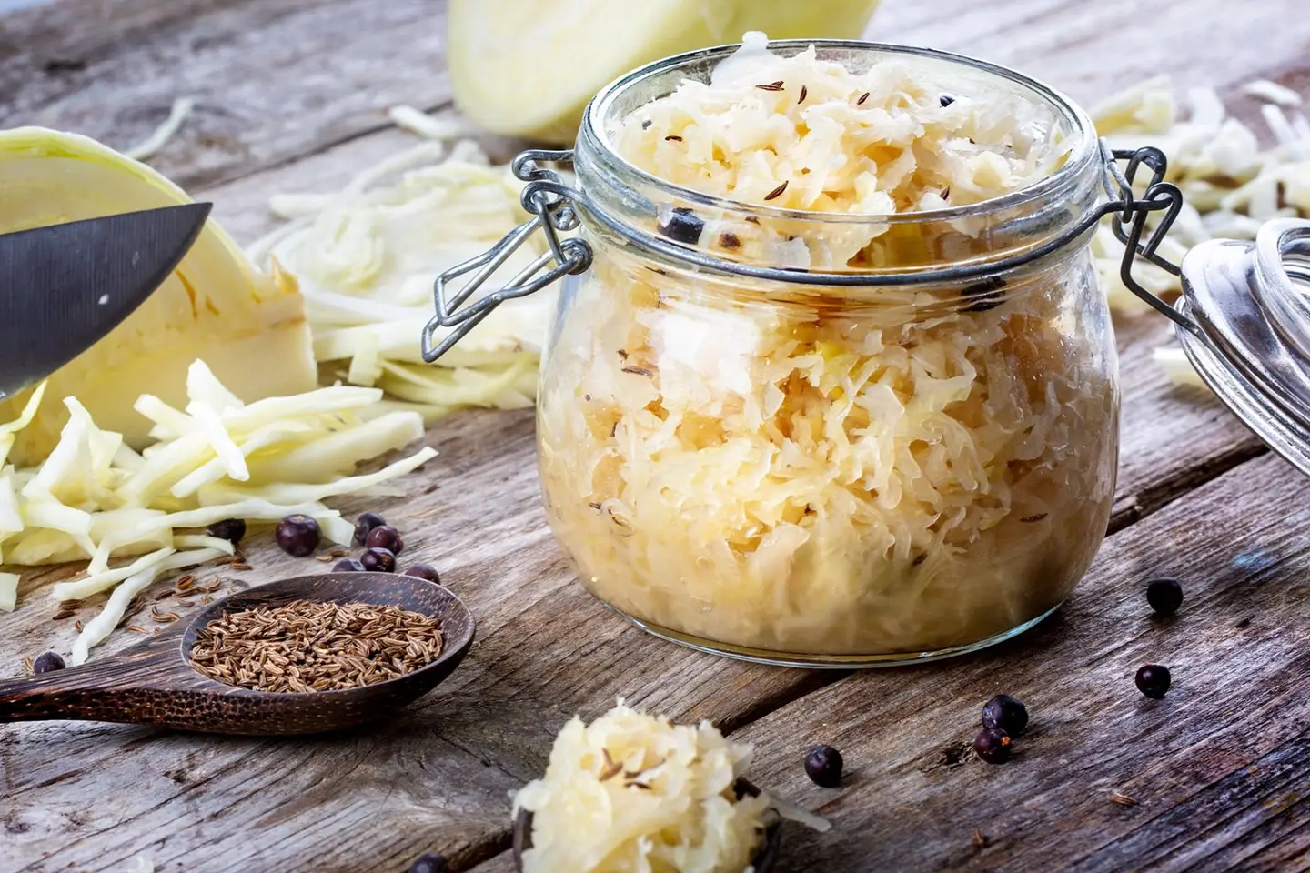 Traditional sauerkraut recipe ingredients ready to ferment on a wooden table